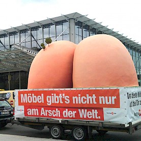 Riesenarsch-Plastik vor Möbelhaus