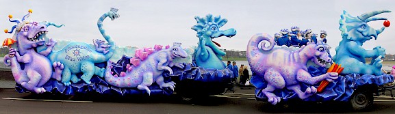 Lustige Dinosaurier an einem Karnevalswagen