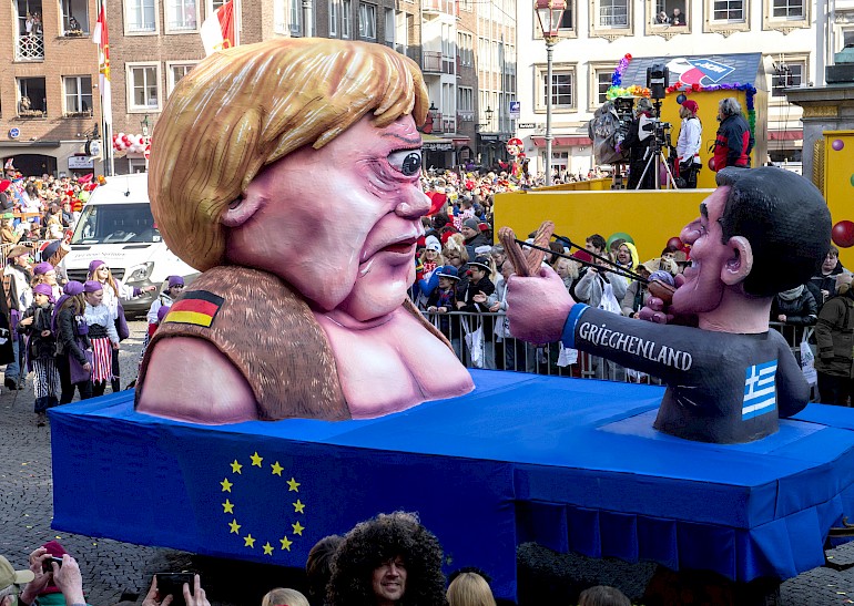 Karikatur: Merkel als Zyklop und Tsipras mit der Zwille