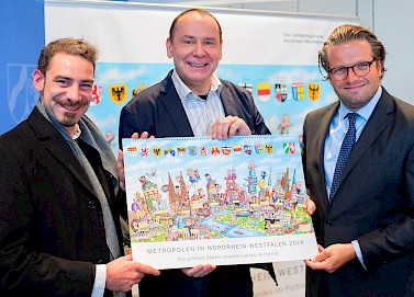 Von links nach rechts: Illustrator David Salomo, Jacques Tilly, NRW-Regierungssprecher Christian Wiermer. Foto: Hojabr Riahi Pressemitteilung auf land.nrw [https://www.land.nrw/de/pressemitteilung/metropolen-nordrhein-westfalen-der-neue-tilly-kalender-fuer-das-jahr-2019]